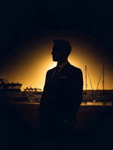 Editorial silhouette portrait against marina at golden hour